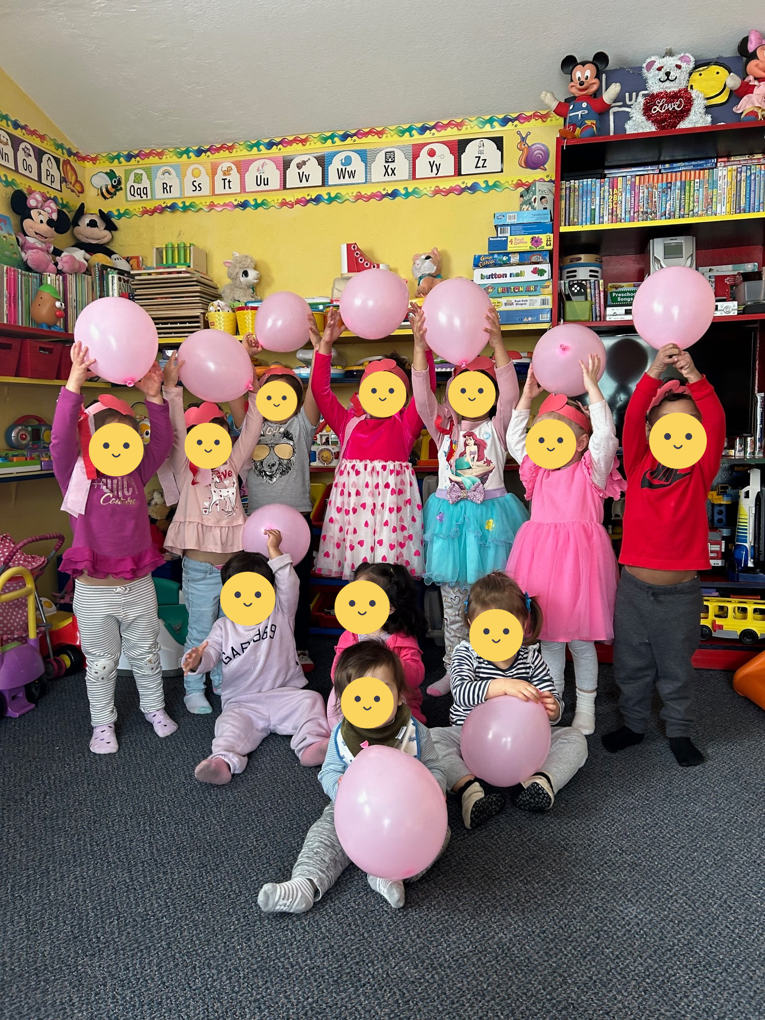 Children posing with pink balloons.